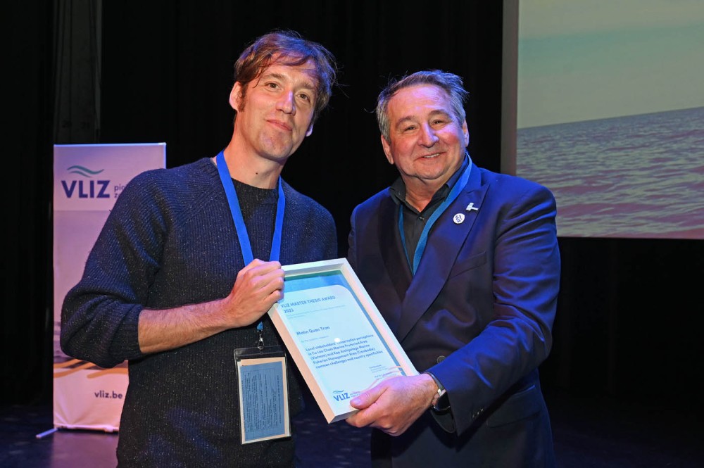 Prof. Jean Hugé neemt de Master Thesis Award in ontvangst namens winnaar QuanTran Manh, met Colin Janssen, voorzitter van de Wetenschappelijke Commissie